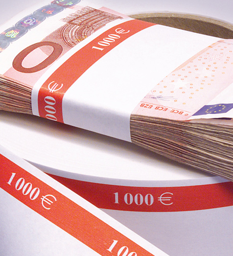 Endless roll of banknote bands and a bundle of cash secured with a banknote band






